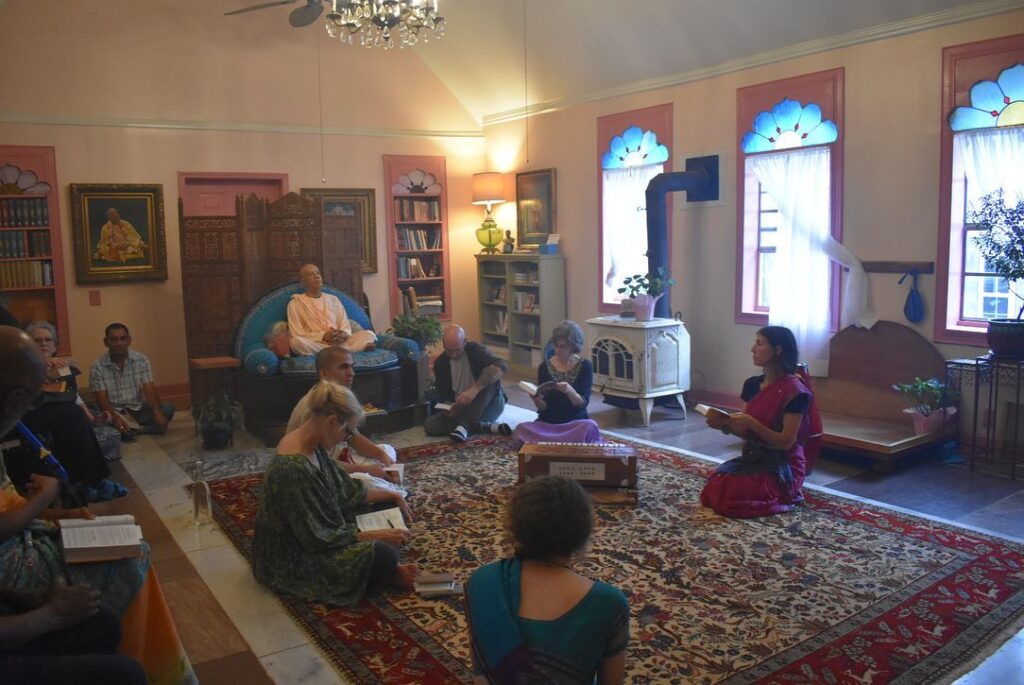 A group of devotees sitting on the temple floor.